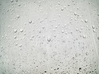 The raindrops are perched on the glass behind the blur.