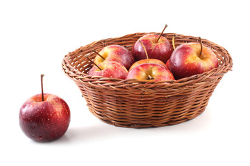 Red little apples on wicker plate