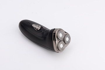 The black electric razor is isolated in the white background