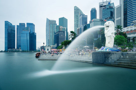Merlion at Marina Bay with business skyscrapers in Singapore. The place is a tourist attraction of Marina Bay, long exposure photography for water movement.