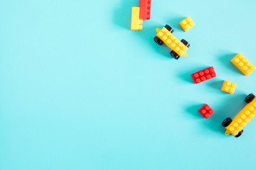 Kids toys and colorful blocks on blue background. Flat lay, top view, copy space