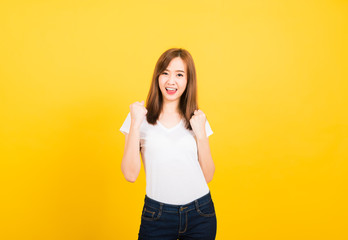 woman teen standing wear t-shirt makes raised fists up celebrating her success