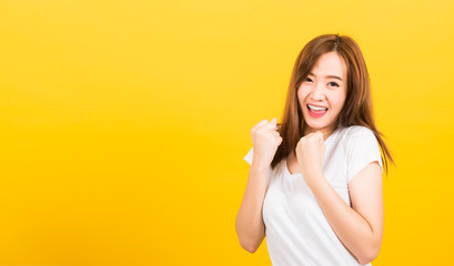 woman teen standing wear t-shirt makes raised fists up celebrating her success