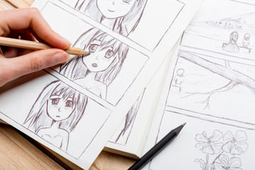 Artist drawing an anime comic book in a studio.