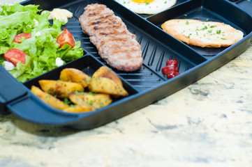 Breakfast, fried steak or cutlet, salad with tomato and green vegetables, toast, potato, egg close-up, light background, copy space. Concept healthy eating, diet, menu, nutritious food.