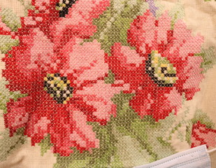 Bright texture of embroidered floral pattern on the canvas fabric. 
