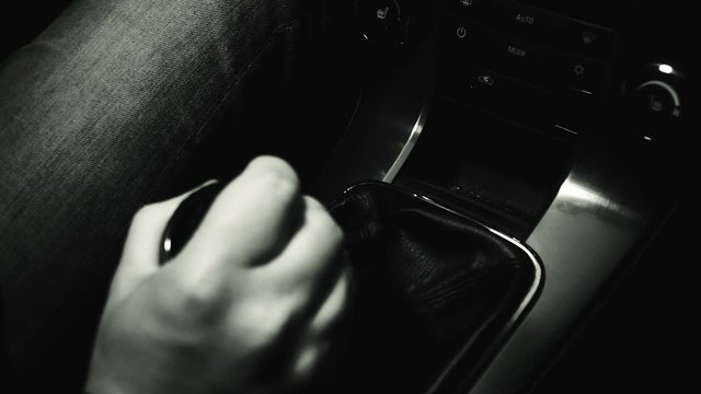 a man in a car switches the manual transmission close up