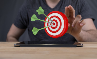 hand holding a target with darts hitting the center over white background. Concept of .
