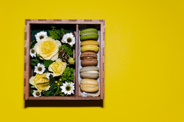 flowers and macaroons in a gift box made of plywood