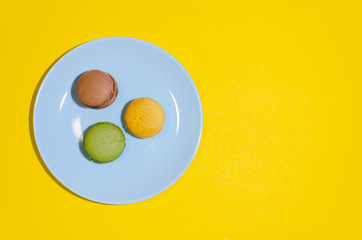 colored macaroons on a blue plate