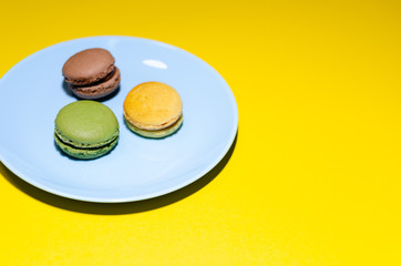 colored macaroons on a blue plate