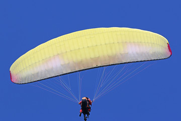 Paraglider flying wing in a blue sky	