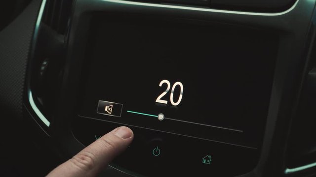 the man turns the sound up and down in the car