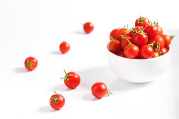 red cherry tomato in  ceramic bowl on white background