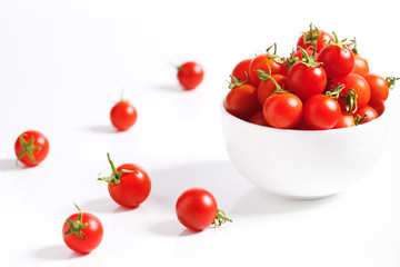 red cherry tomato in  ceramic bowl on white background