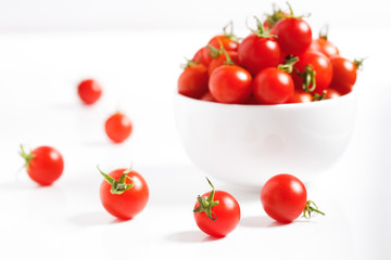 red cherry tomato in  ceramic bowl on white background