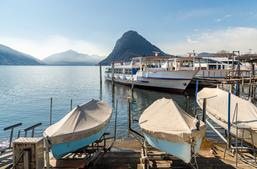 Landscape of Lake Lugano with boats at pier and  Monte San Salvatore, Lugano