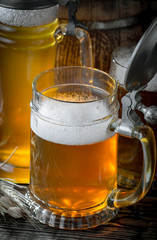 Light frothing beer in a glass, on an old background.