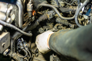 Car mechanic servicing car engine in car service closeup