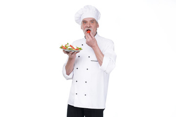Food service, organic food, healthy diet, cooking and professional culinary concept, elderly chef in white uniform holds vegetable salad