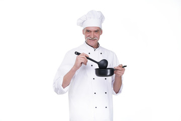 Man with beard cook with excited face in uniform with ladle, restaurant cuisine concept. Chef tastes soup or compote