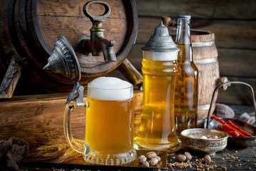 Light frothing beer in a glass, on an old background.