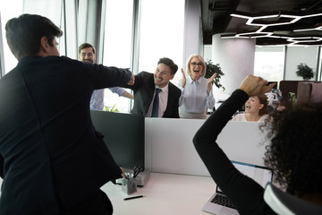 Overjoyed diverse businesspeople have fun celebrate company shared business success or win in...