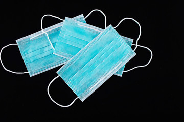 Disposable medical mask on a black background. The concept of protection against bacteria and viruses.