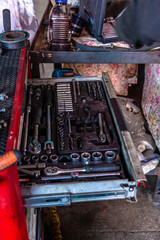 The mechanic in the car service picks up a tool for repairing the car