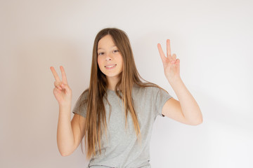 Young girl smiling with victory gestures