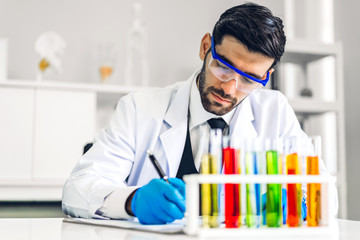 Professional scientist man research and working doing a chemical experiment while making analyzing and mixing  liquid in test tube at laboratory
