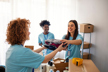 Volunteers Collecting Food Donations In Warehouse. Happy team of volunteers holding donations boxes...