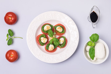 White Plate of Classic Italian Caprese Salad Ripe Tomatoes Fresh Basil Leaf Bowl with Mozarella Cheese Flat Lay Top View Salad and Ingredients