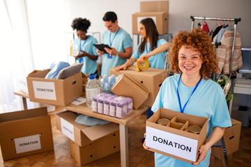 Small group of people working on humanitarian aid project. Cheerful food drive manager. Confident...