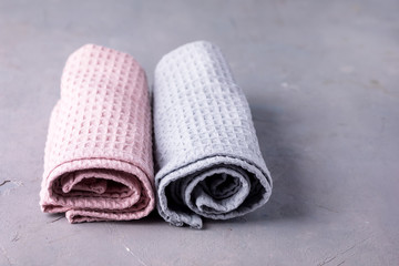 Two Towels Tolled Up on a Gray Background Pink and Gray Towels Horizontal