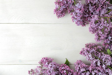 Spring flowers. Frame of twigs of blooming lilac on a white wooden table. top view. place for text