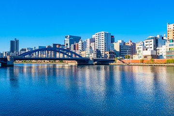Naklejka premium Japan. Tokyo. Panorama of Tokyo Bay. Bridge over the bay. Capital of Japan in sunny weather. Tokyo on the background of blue sky. Embankment on the background of skyscrapers. Trip to Japan.