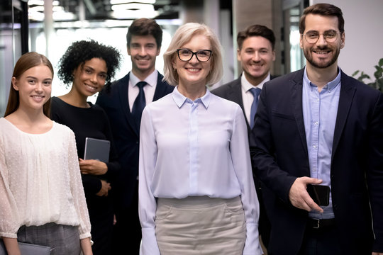 Group picture of smiling multiracial employees team pose together looking at camera in office, happy diverse multiethnic colleagues show unity and motivation at work, career, employment concept