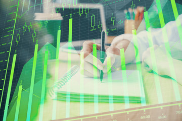 Obraz na płótnie Canvas Forex chart displayed on woman's hand taking notes background. Concept of research. Double exposure