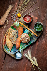 Various home-made breads and pastries on a tray on a wooden background, rustic style