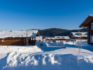 Alpine Village in the ski resort Mountain Salanga. Winter sunny day. Hotel houses