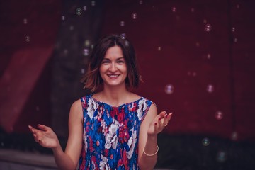 Young woman laughs and enjoys soap bubbles around her