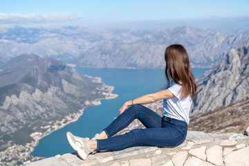 Fototapeta na wymiar Young girl admiring the scenery from the viewpoint in Montenegro