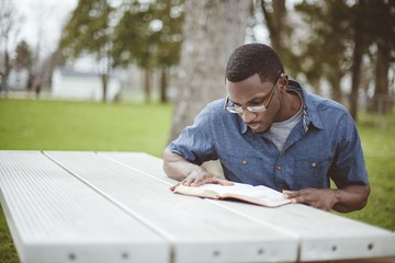 African-American male sitting at a table and reading the Bible