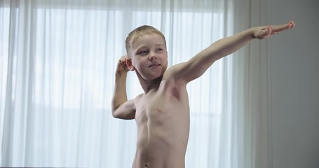 Happy child doing sports at home, boy fitness training dumbbells - Powered by Adobe