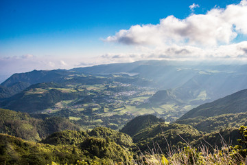 Paisaje montañoso de la Isla de Sao Miguel en las Islas Azores de Portugal con los rayos del sol entrando por las nubes en el cielo