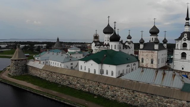 A slow flight near the walls and towers of the Solovetsky Kremlin on a cloudy day with soft lighting. This is part of the fortress of the Solovetsky monastery (1420)