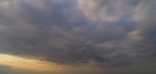 Dark cloudy sky with red reflections at sunset.