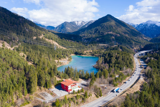lake urisee next to highway with hotel in austrian mountains at spring