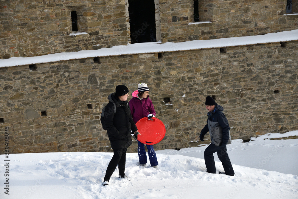 Wall mural tourist hiking in the ruins castle on the snow in slovakia zborov ruins